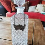 Chiseled glass whiskey decanter and its necklace marked “whiskey”