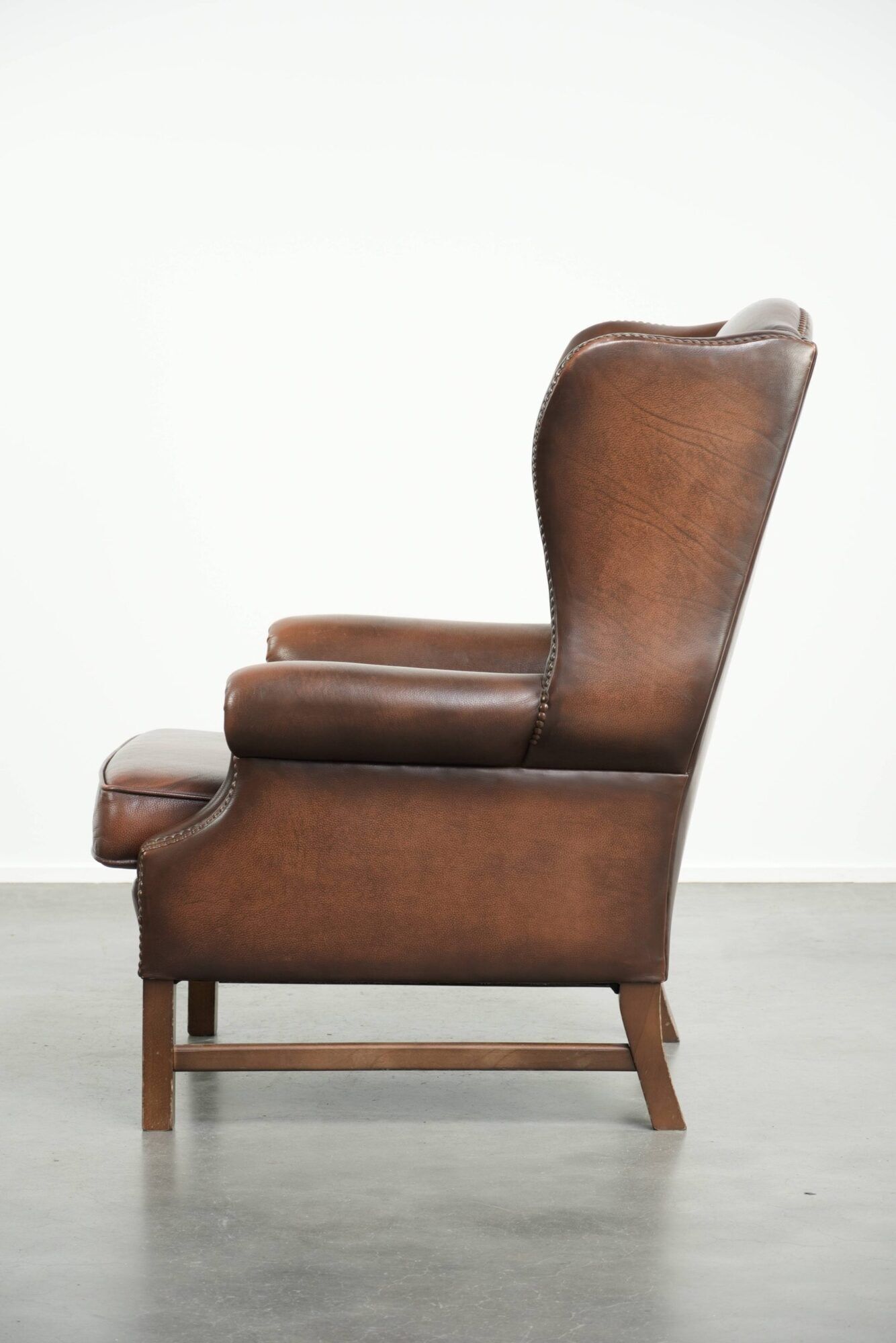 Cowhide wingback armchair in English style finished with decorative nails