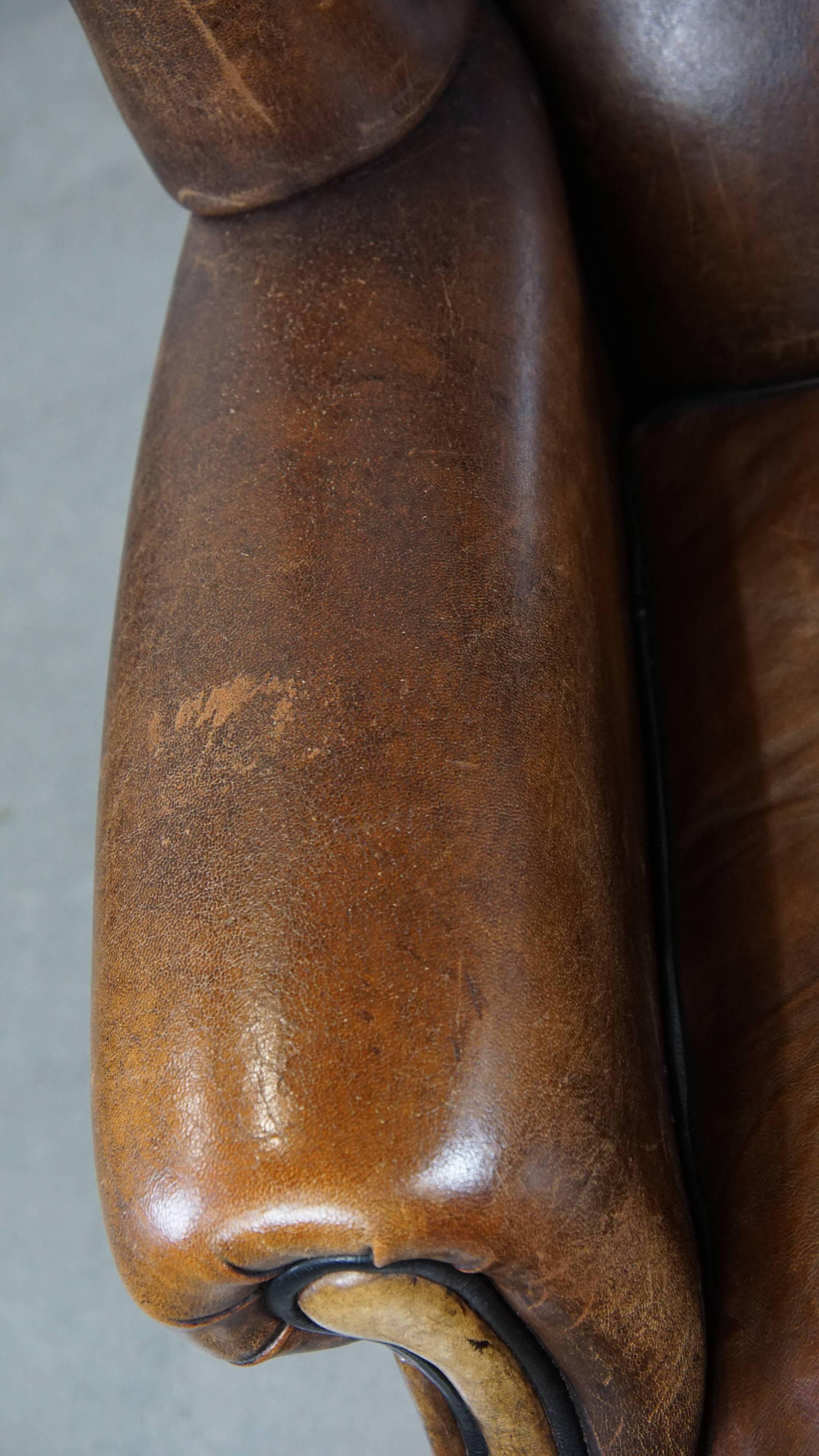 Vintage sheepskin wingback chair finished with black piping