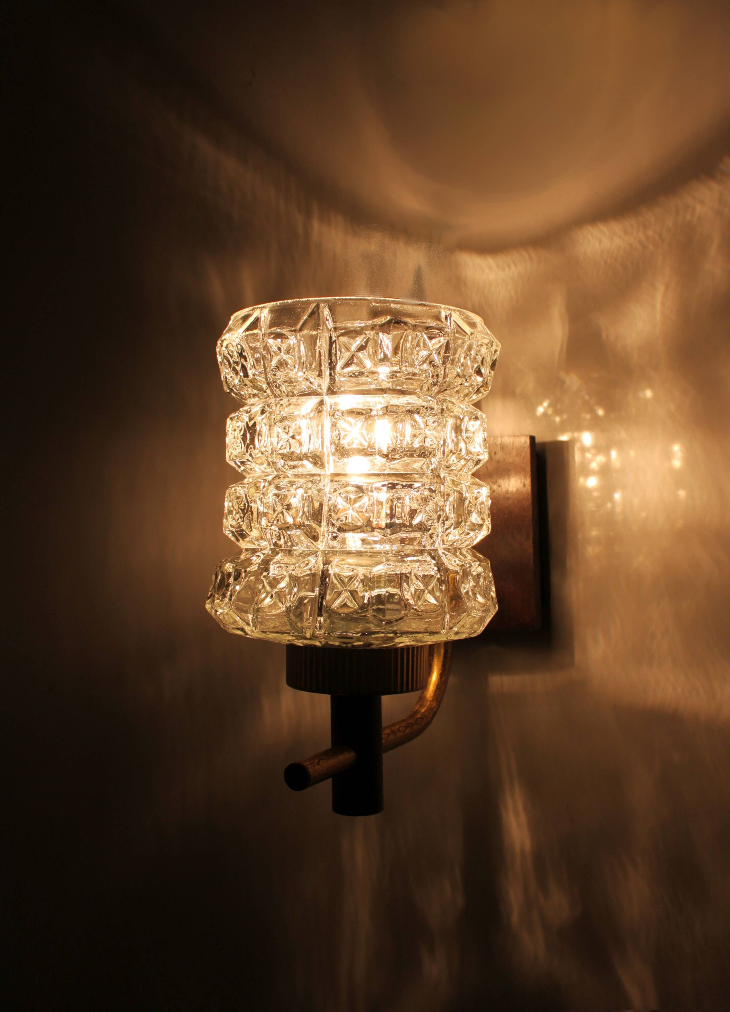 Pair of wall sconces in textured glass, wood, and gold metal, 1970.
