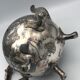 Old teapot pourer in silver metal decorated with foliage and butterflies