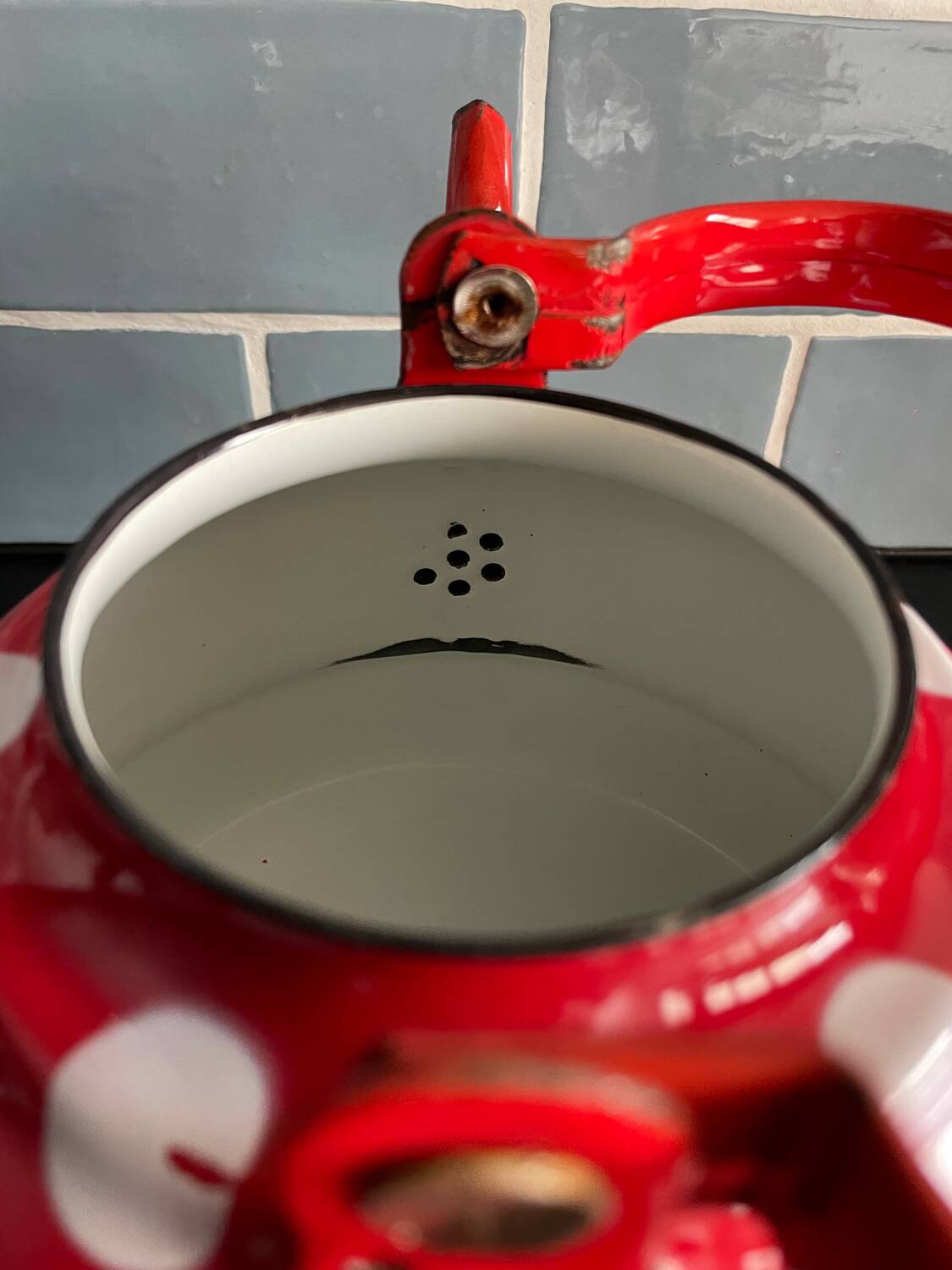 Red enameled sheet metal kettle with white polka dots