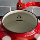 Red enameled sheet metal kettle with white polka dots