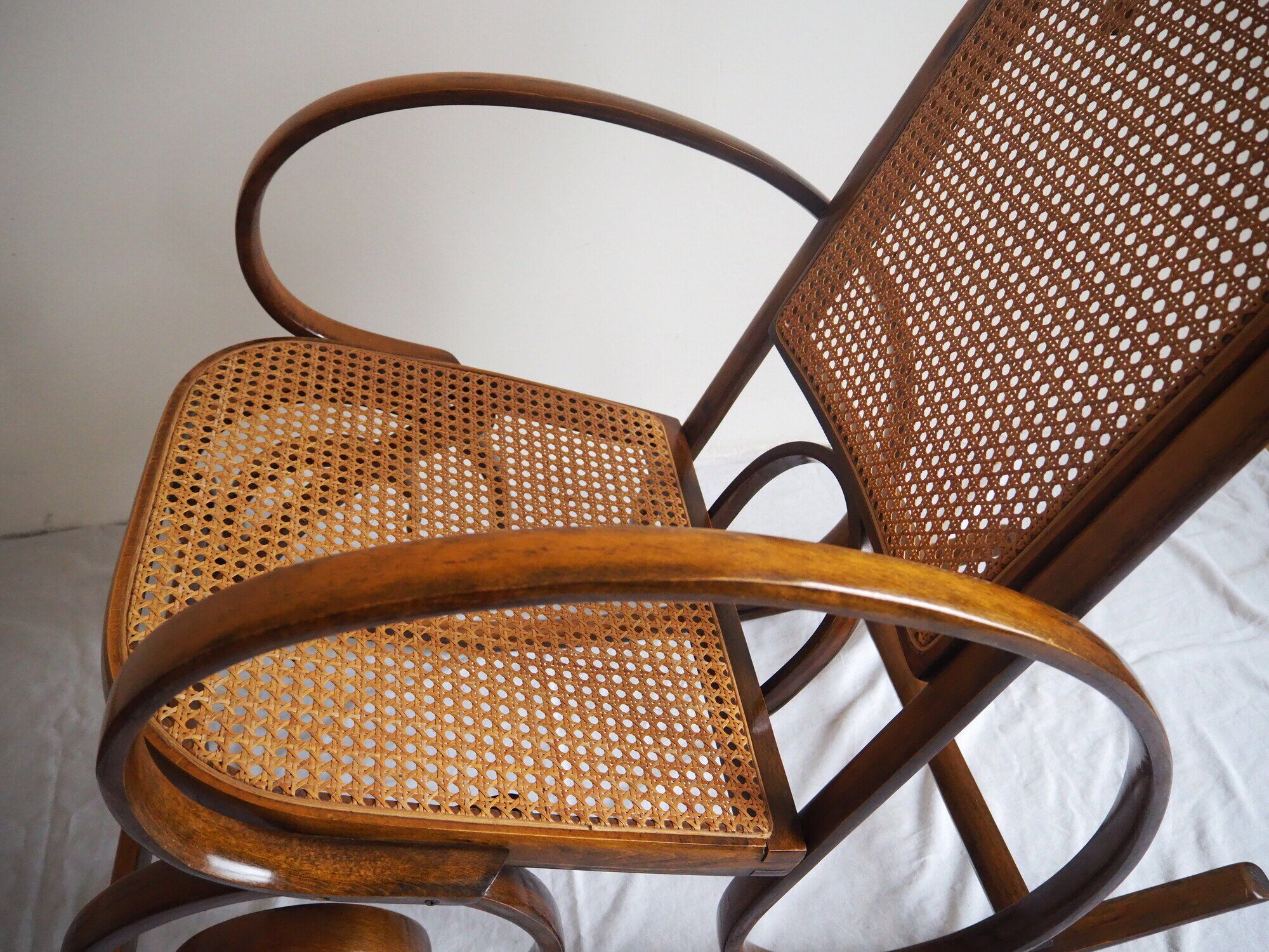 Rocking-chair en bois teinté et assise cannée