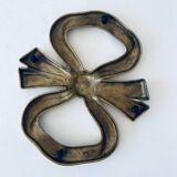 Bow-shaped brass trivet