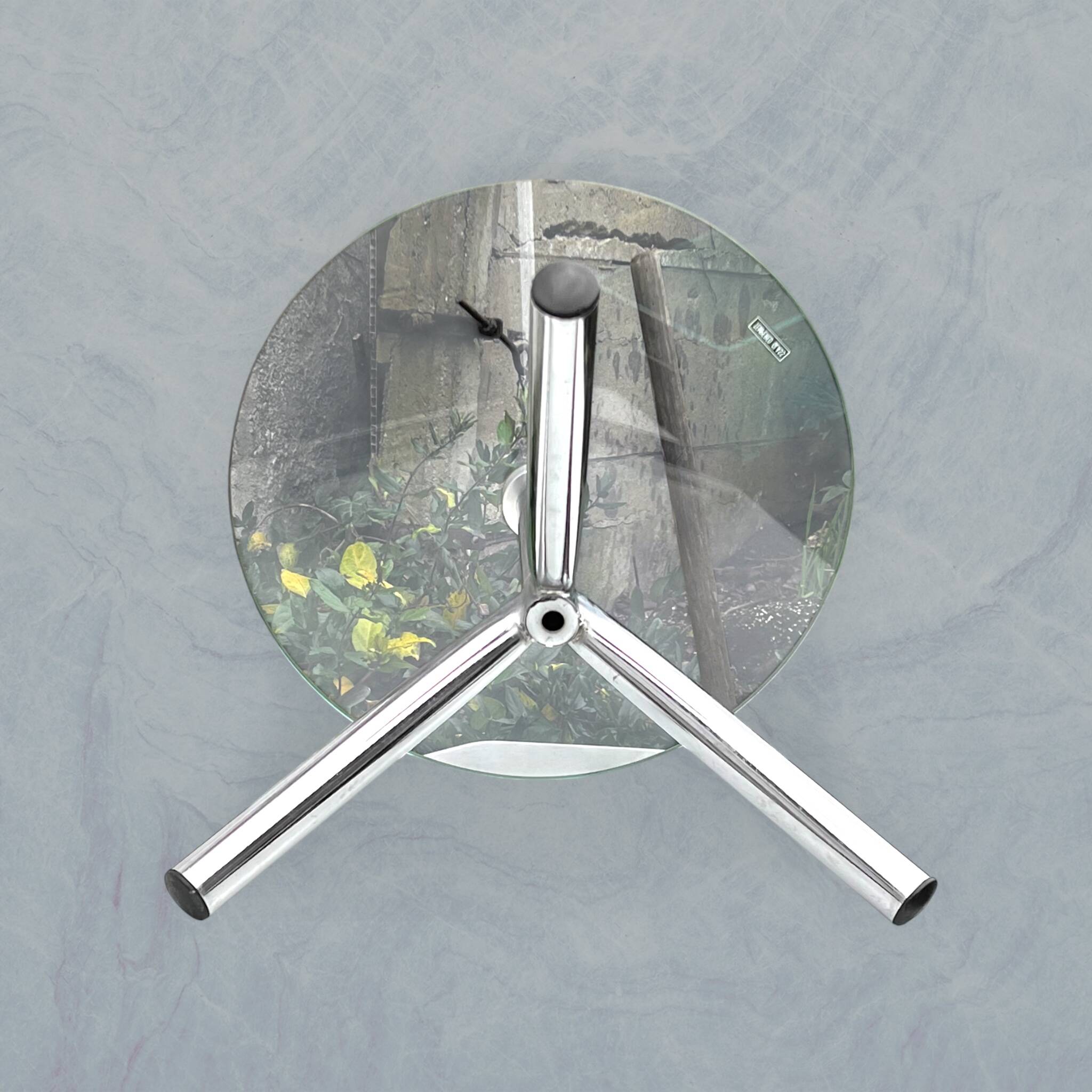 Modernist tripod side table in tempered glass and chrome metal.