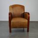 Luxurious cowhide Art Deco design armchair with wooden armrests and cognac-colored leather