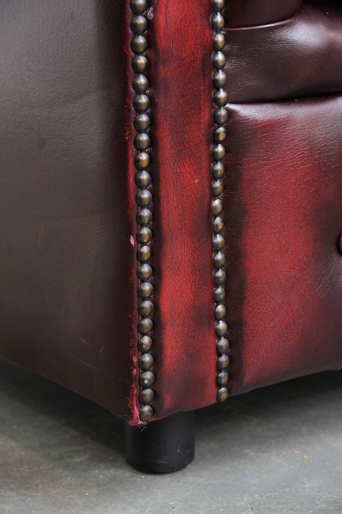 Red English cowhide Chesterfield armchair finished with decorative nails