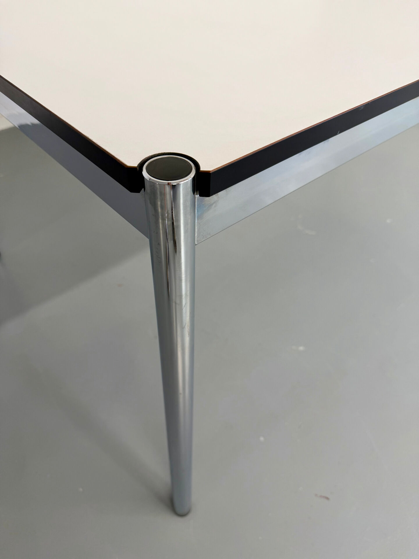 Large table design USM Haller with a white top and chrome structure.