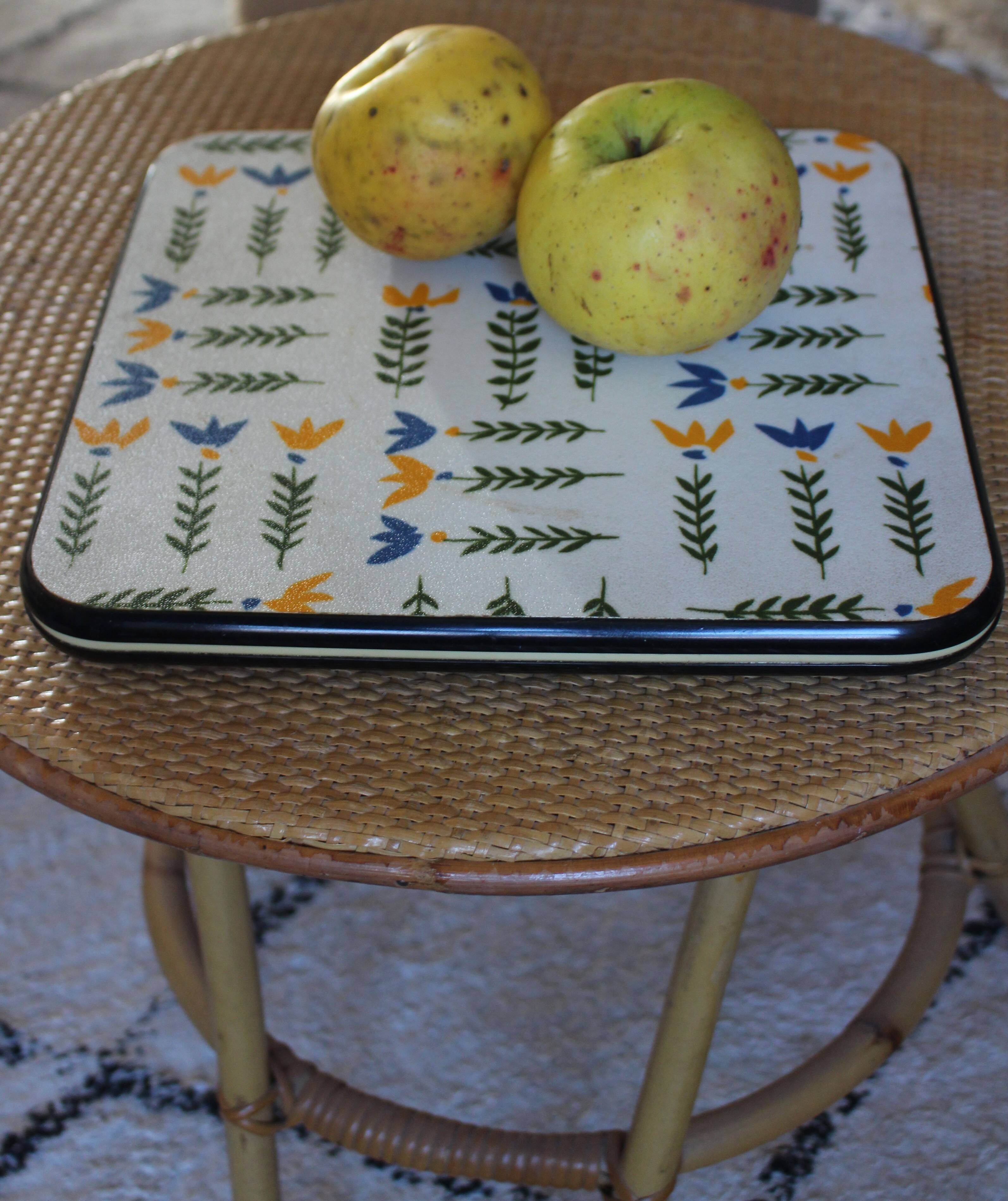 Vintage laminated wooden trivet with yellow, green, and blue flowers