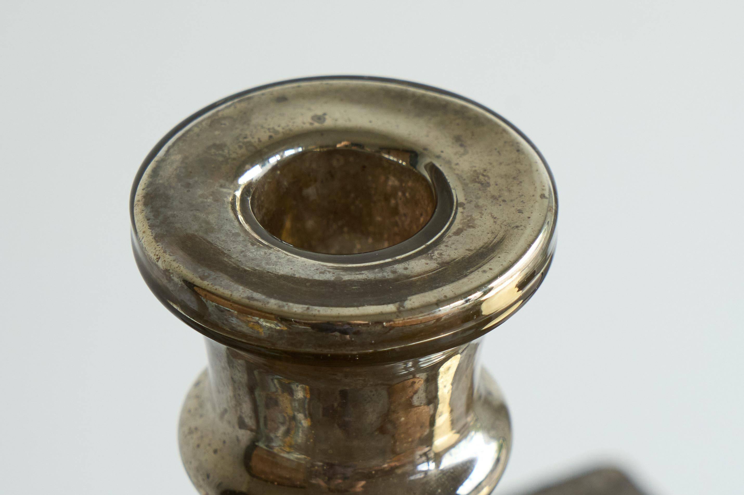 Antique mercury glass candlestick with a patina and silver finish.