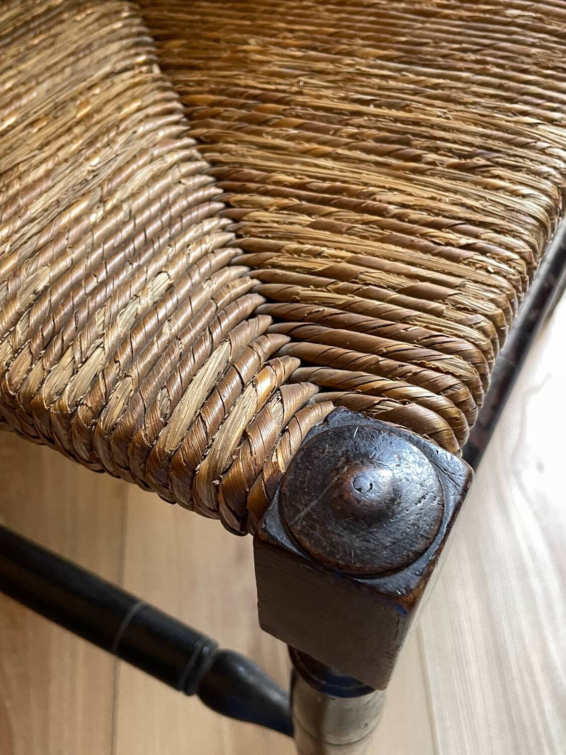 Corner chair made of turned wood with a straw seat.