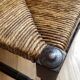 Corner chair made of turned wood with a straw seat.