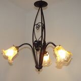 French Art Nouveau leaf detail iron three-light chandelier with amber glass shades.
