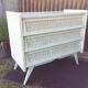 Commode vintage pieds compas tiroirs en rotin laquée blanc.