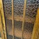 Vintage wooden display cabinet with textured glass.