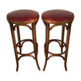 Pair of wooden bistro stools turned and sitting in 20th century red skai