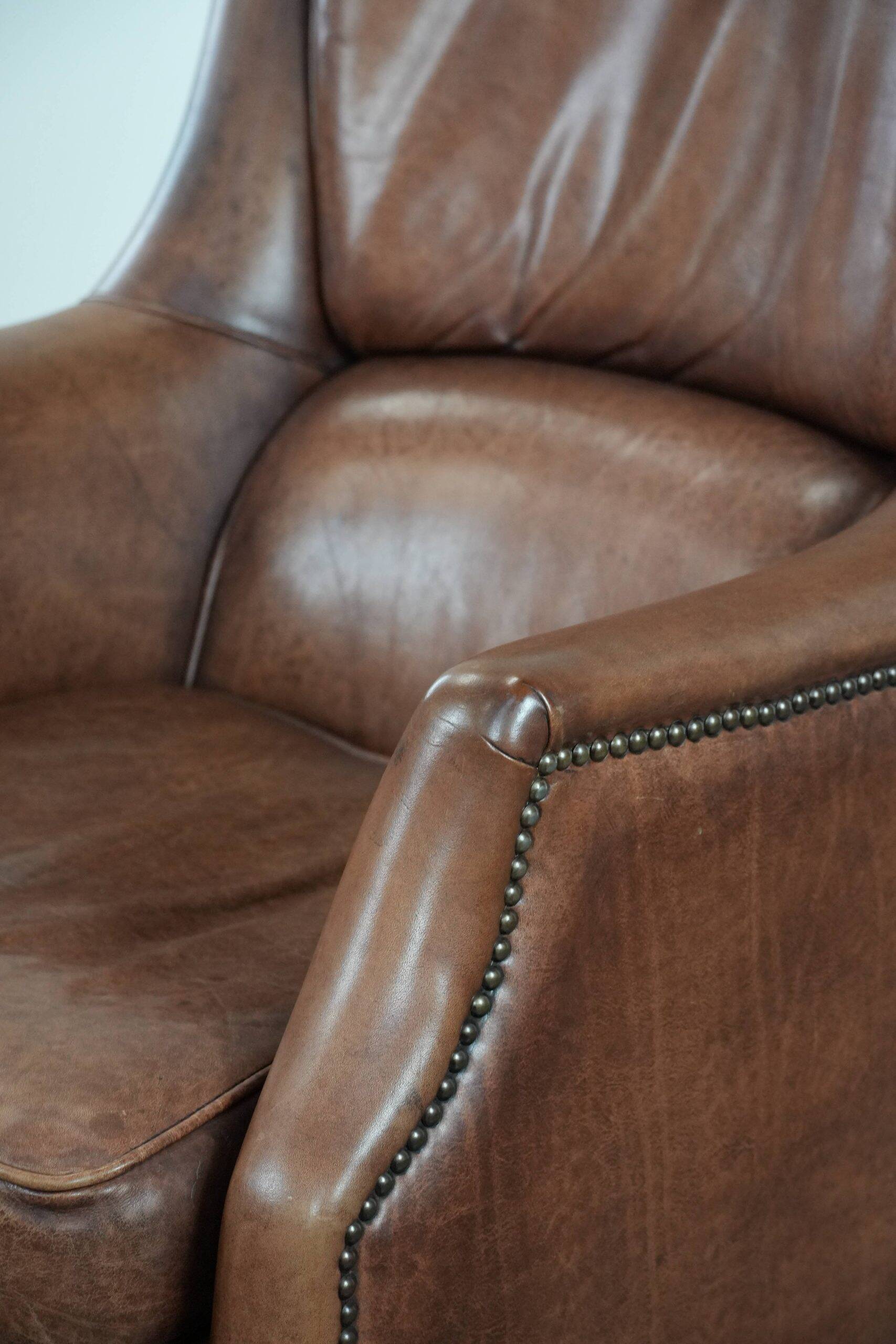 Cognac brown cow leather armchair with decorative nail finish