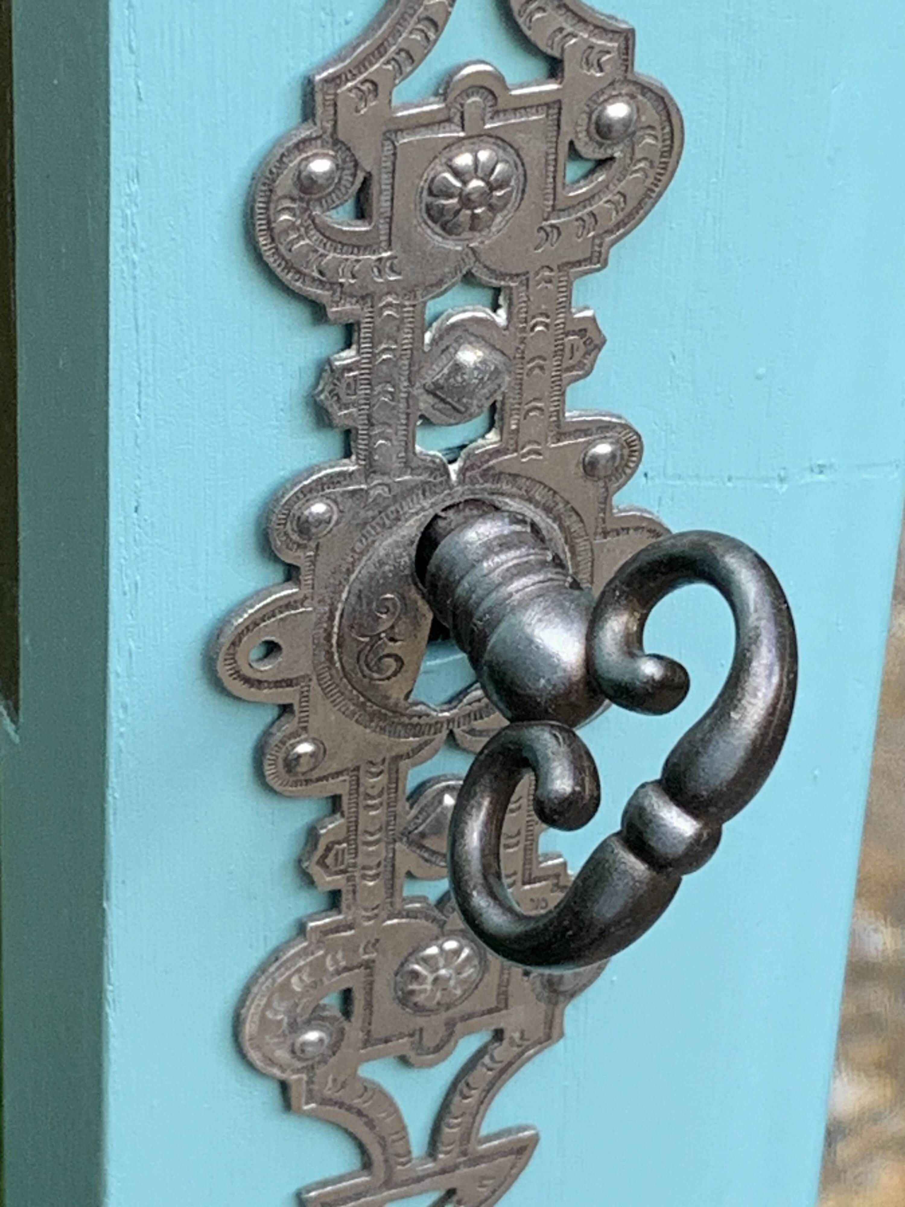 Beveled mirror on turquoise Parisian door
