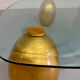 Vintage Italian design coffee table with a glass top and gold base, dating from the 1980s.