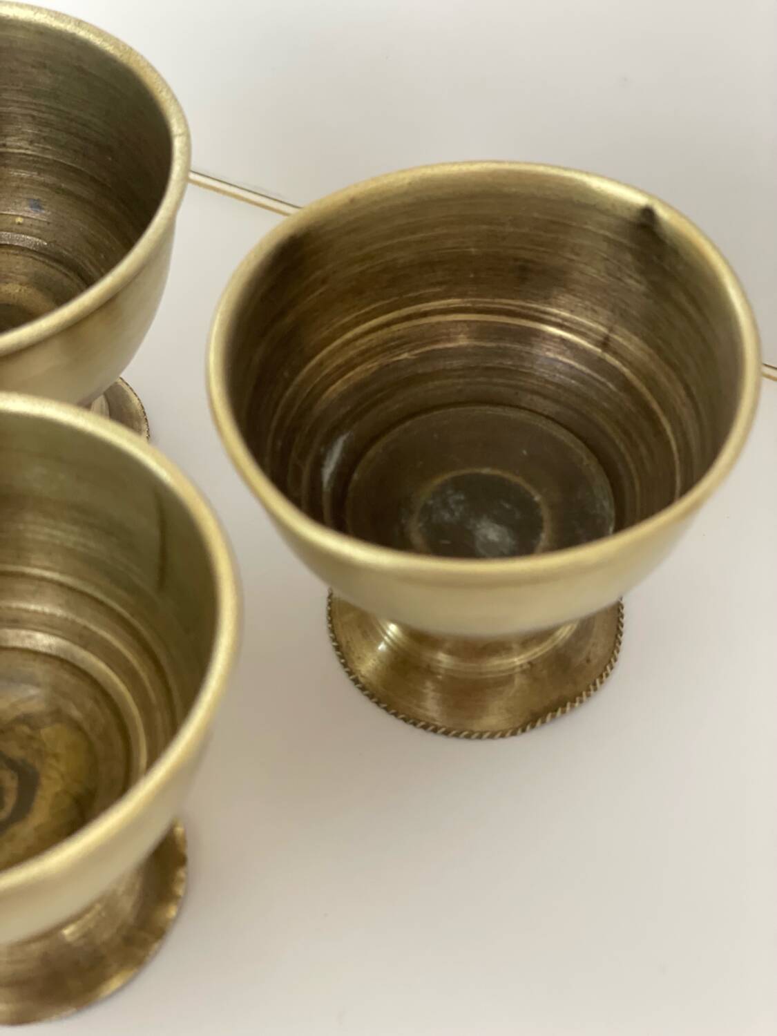 4 golden brass egg cups
