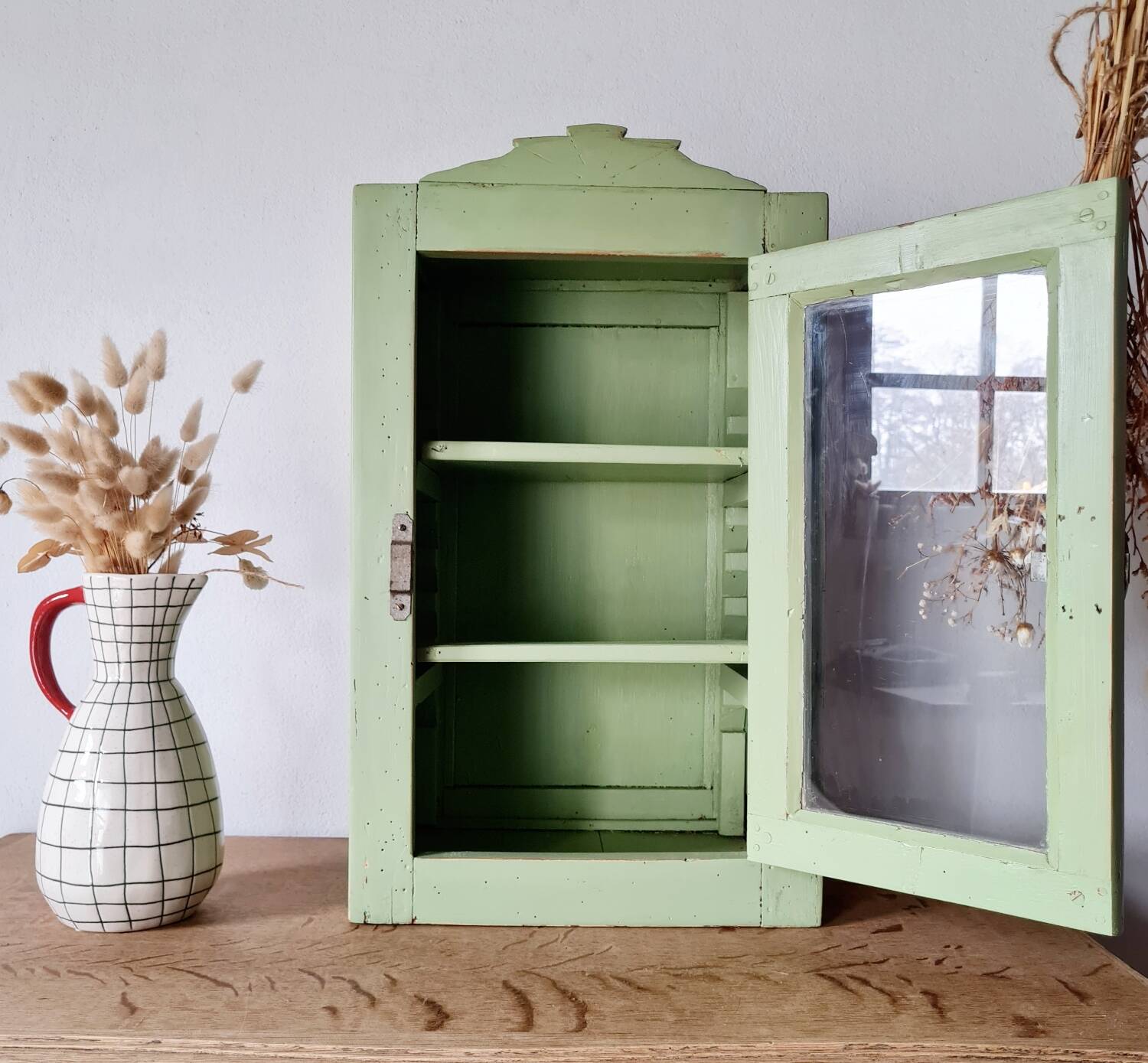 Small glass cabinet in green colour.