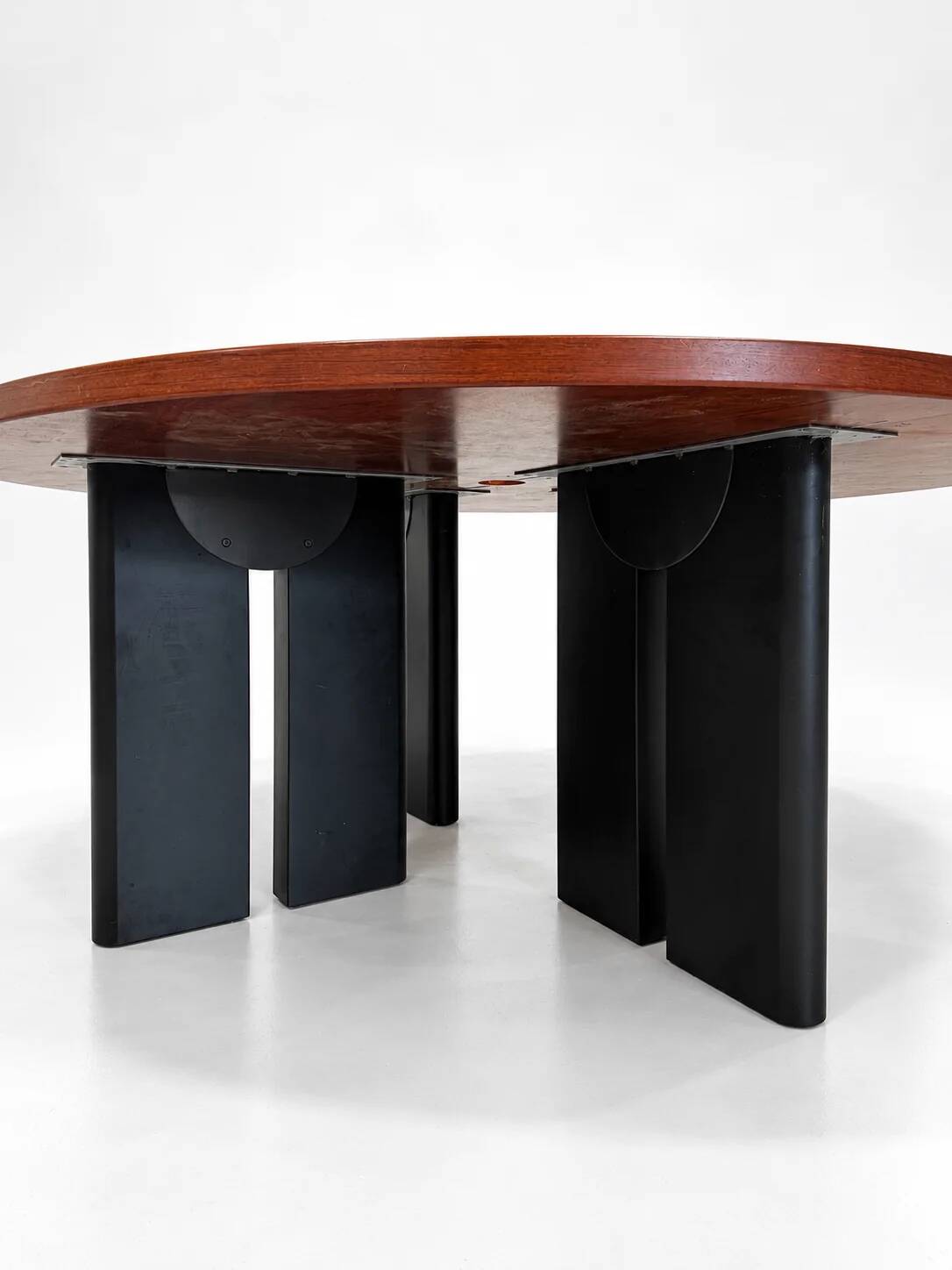 Large round dining table with black blade legs.