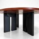 Large round dining table with black blade legs.
