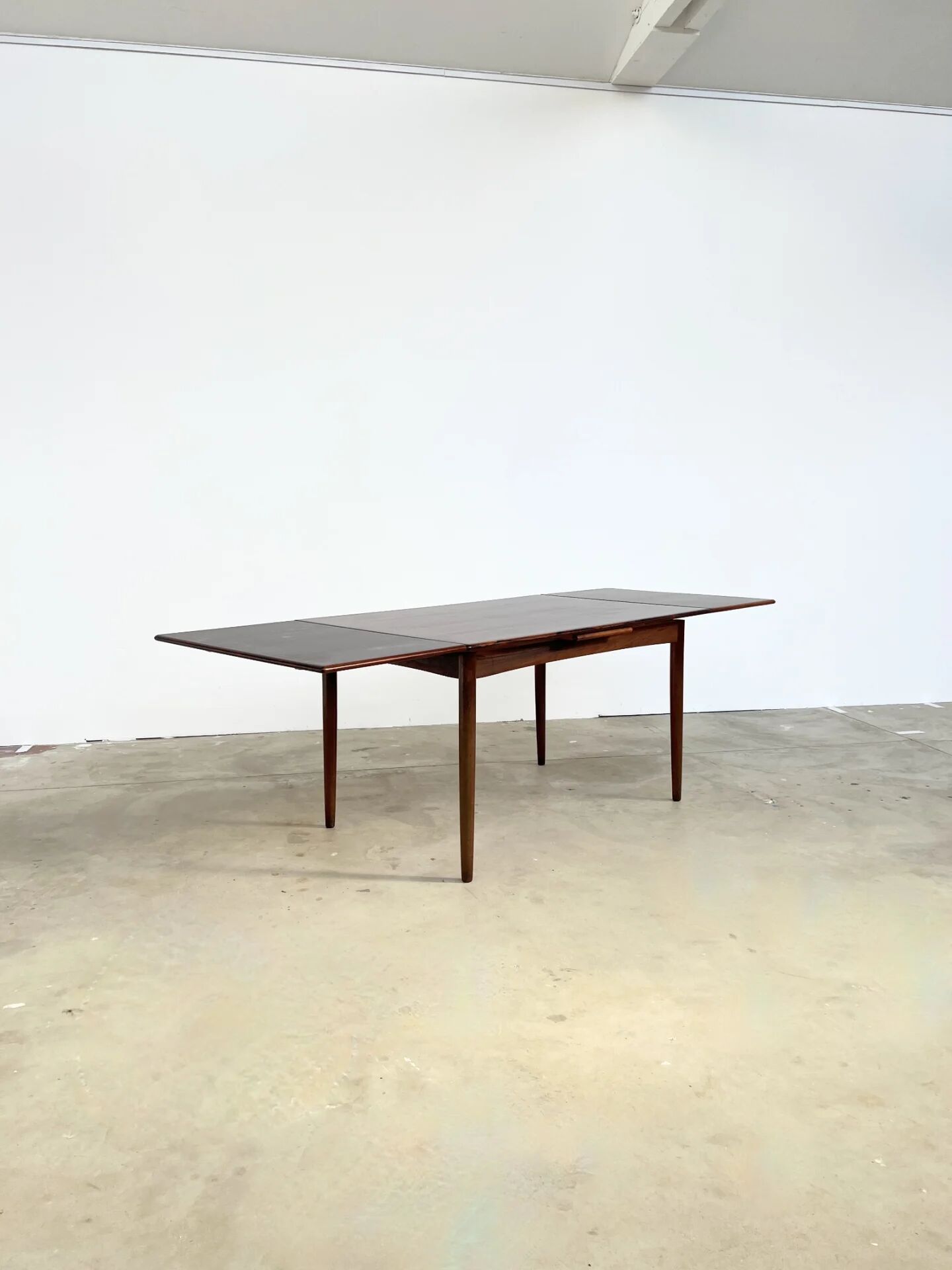 Rosewood dining table with integrated extensions — Denmark, 1960s