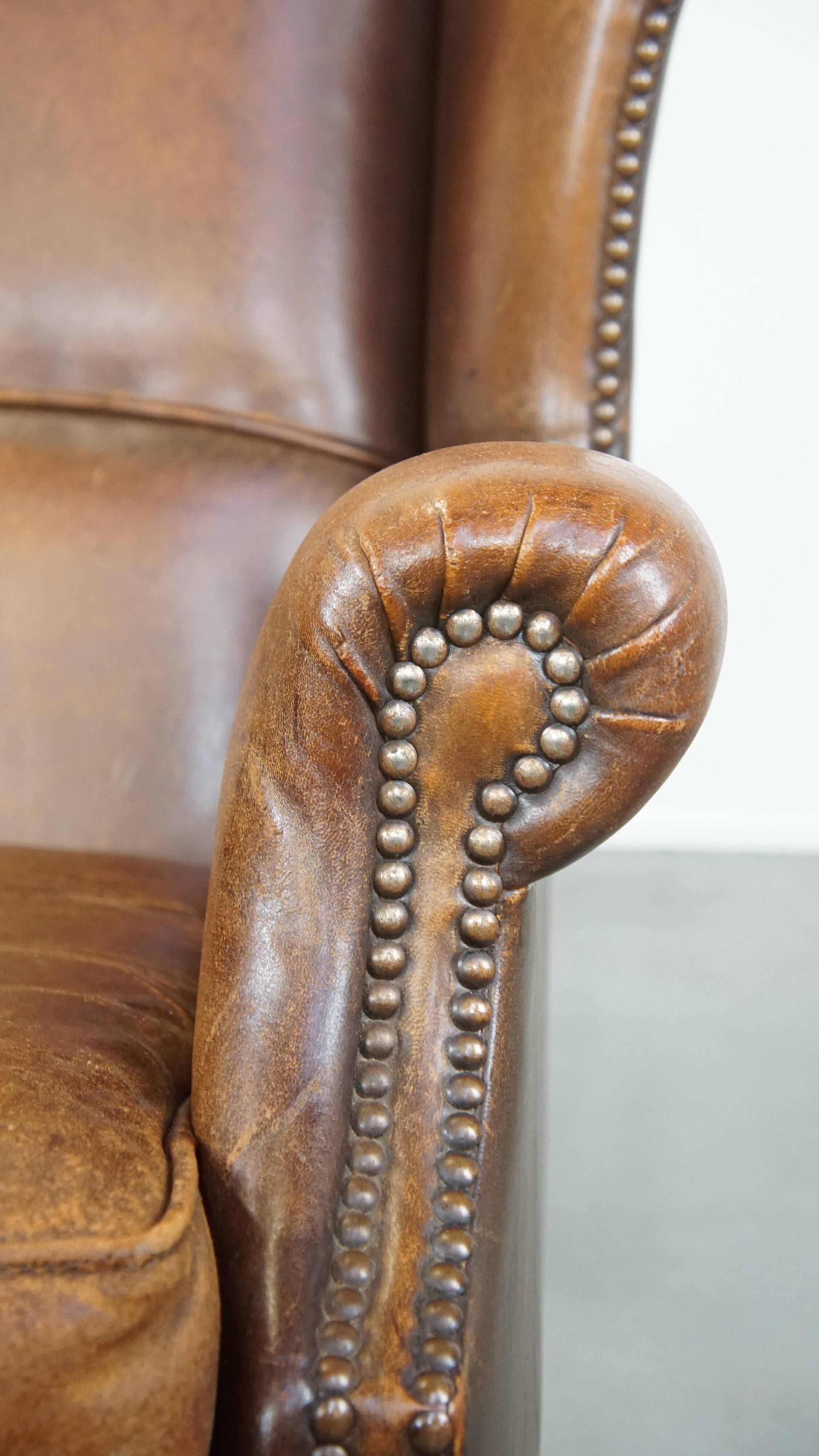 Cognac-colored sheepskin wing chair in English style