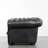 Comfortable black chesterfield armchair made of cowhide leather