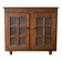 Small antique wooden sideboard with glass doors.