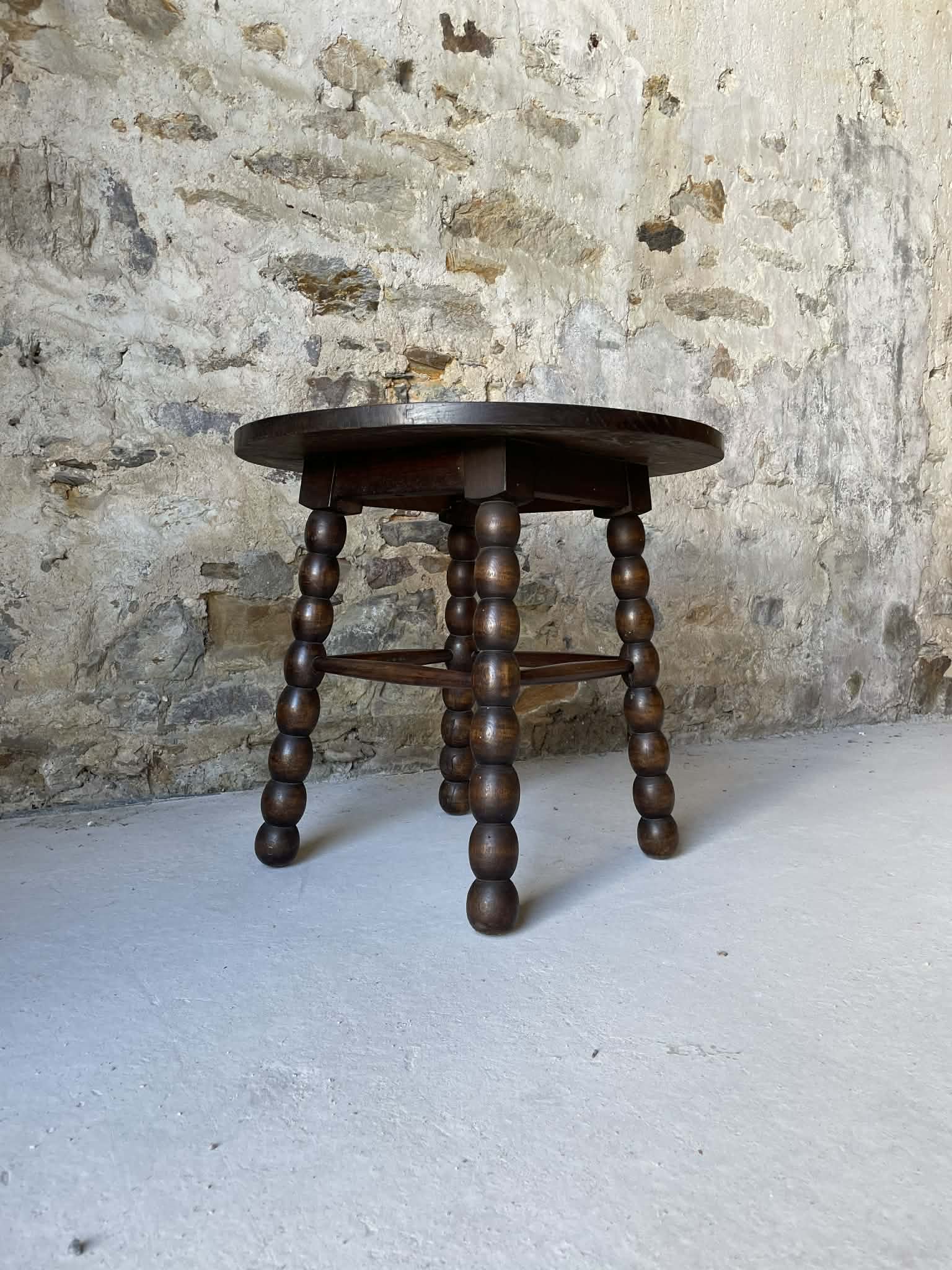 Round wooden coffee table with turned legs.