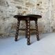 Round wooden coffee table with turned legs.