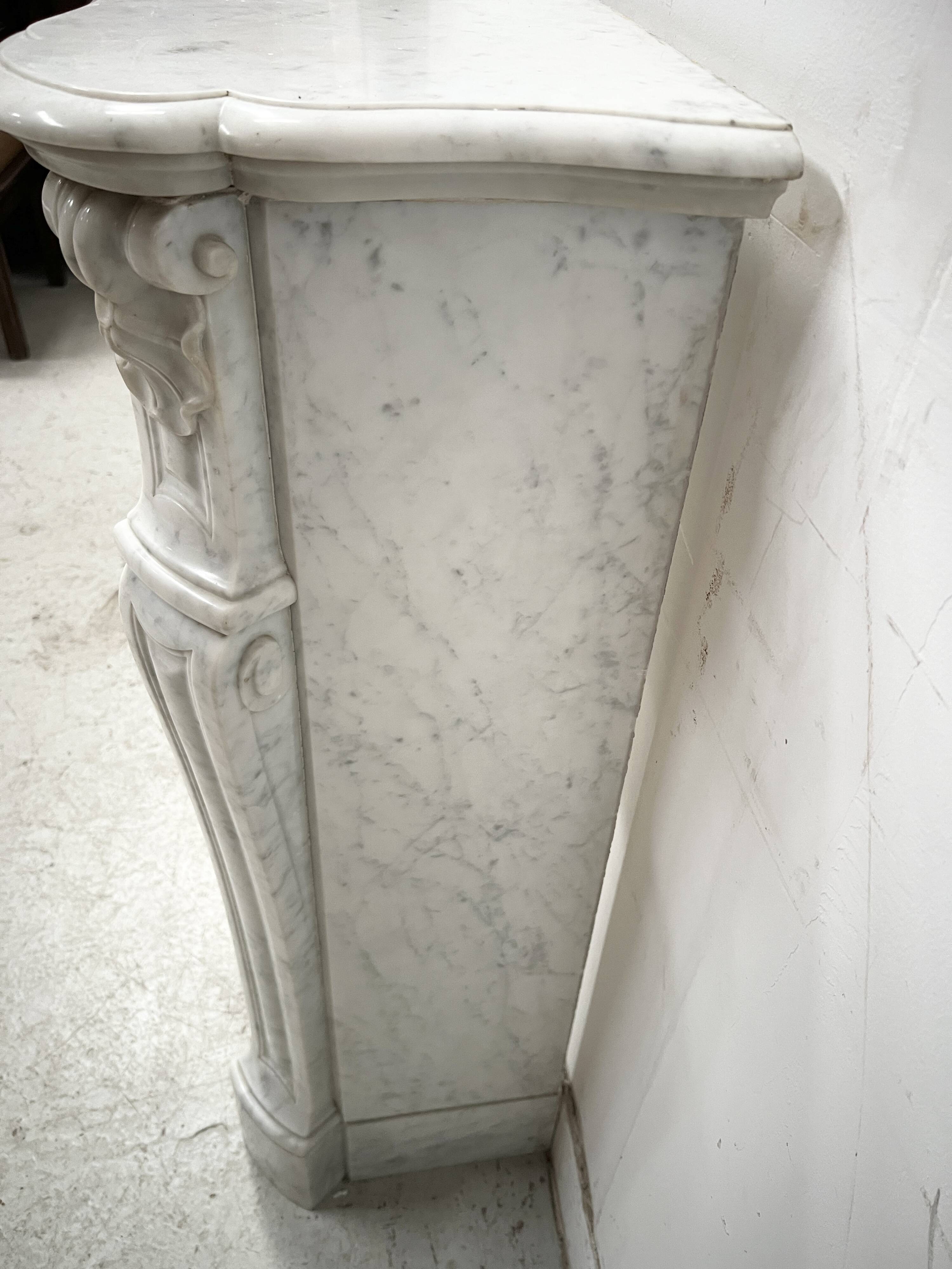 Louis XV style fireplace in veined white marble, 20th century.