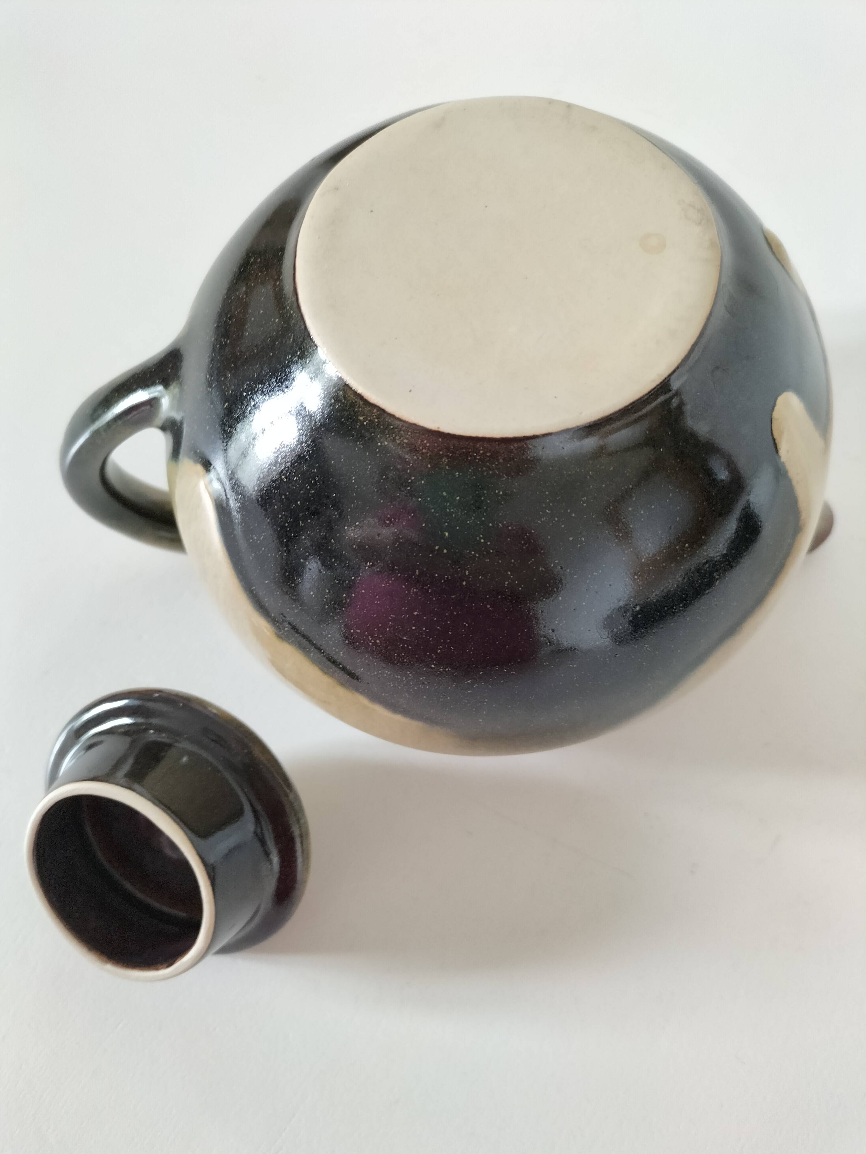 Vintage ceramic teapot with a flame design.