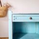 Small vintage bedside table with patinated azure blue wood.