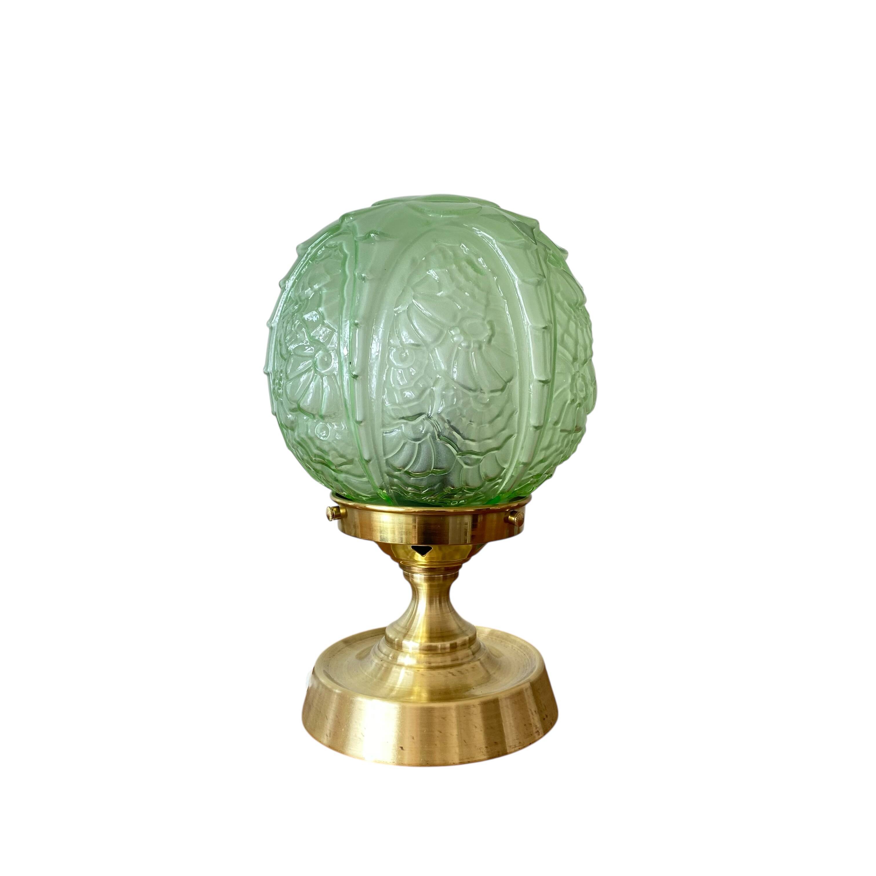 Art Deco green moulded glass globe table lamp with a brass base.