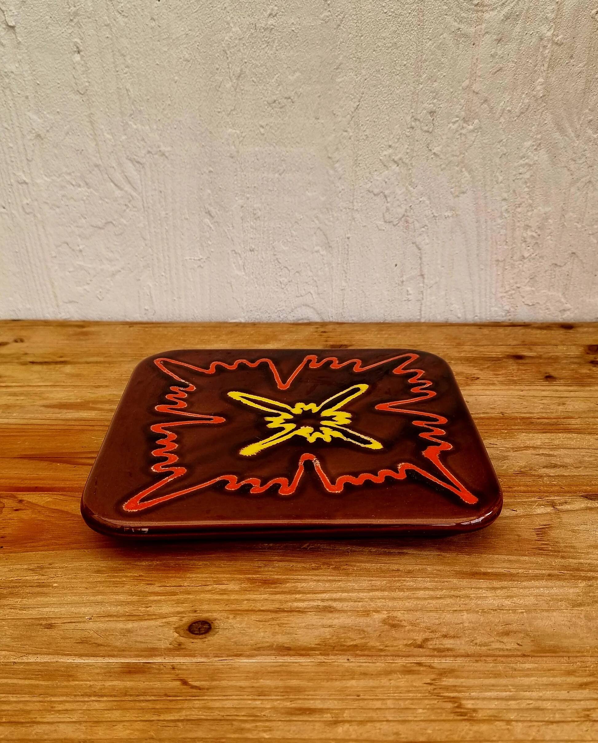 Vintage ceramic trivet with a 70s pattern.
