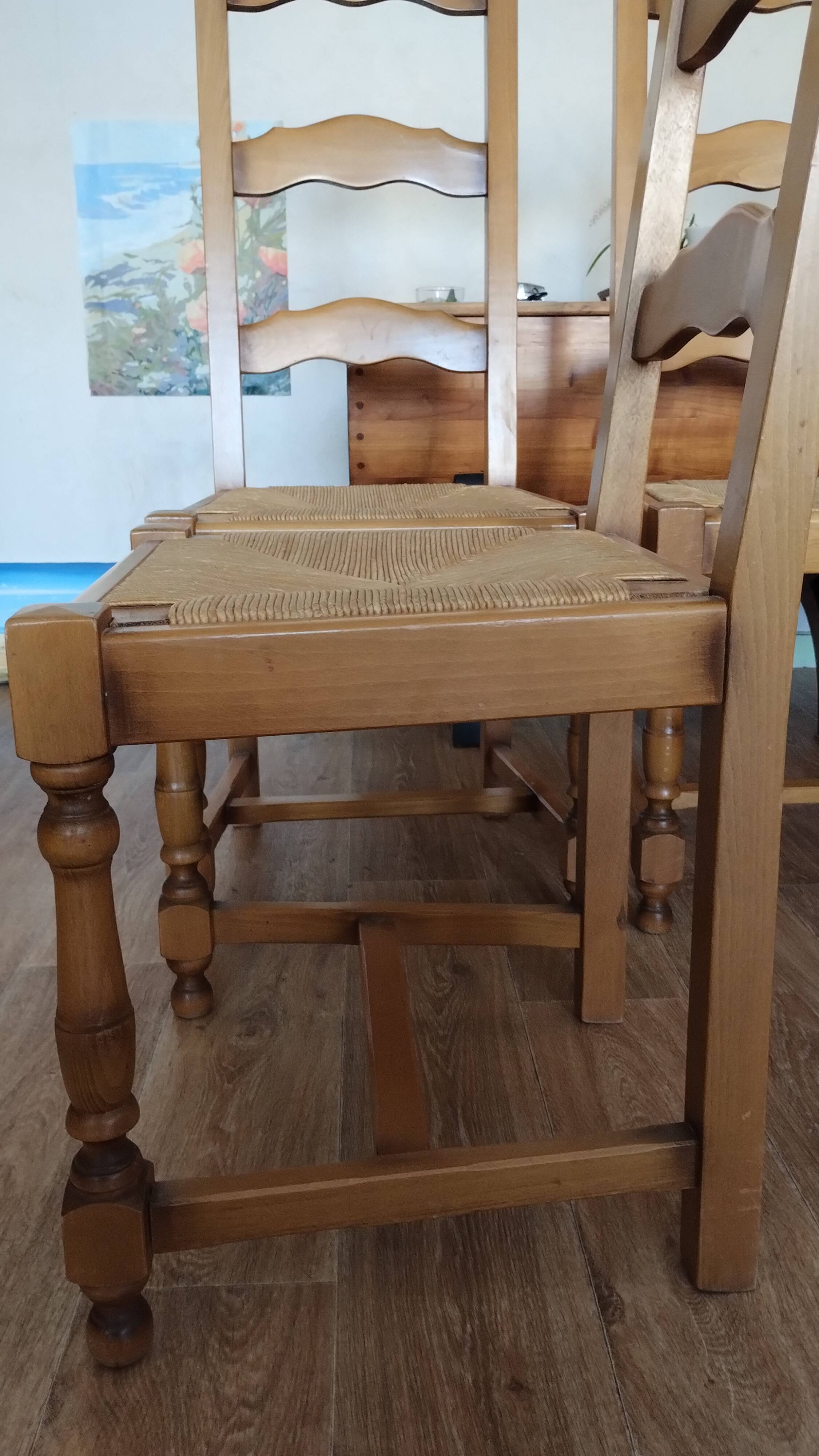 4 straw-seated solid wood chairs with high backs in rustic style.