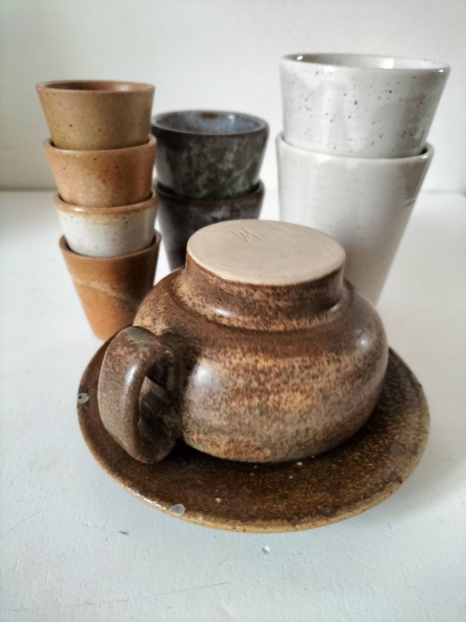 Set of 8 stoneware cups and a mug, shades of beige.