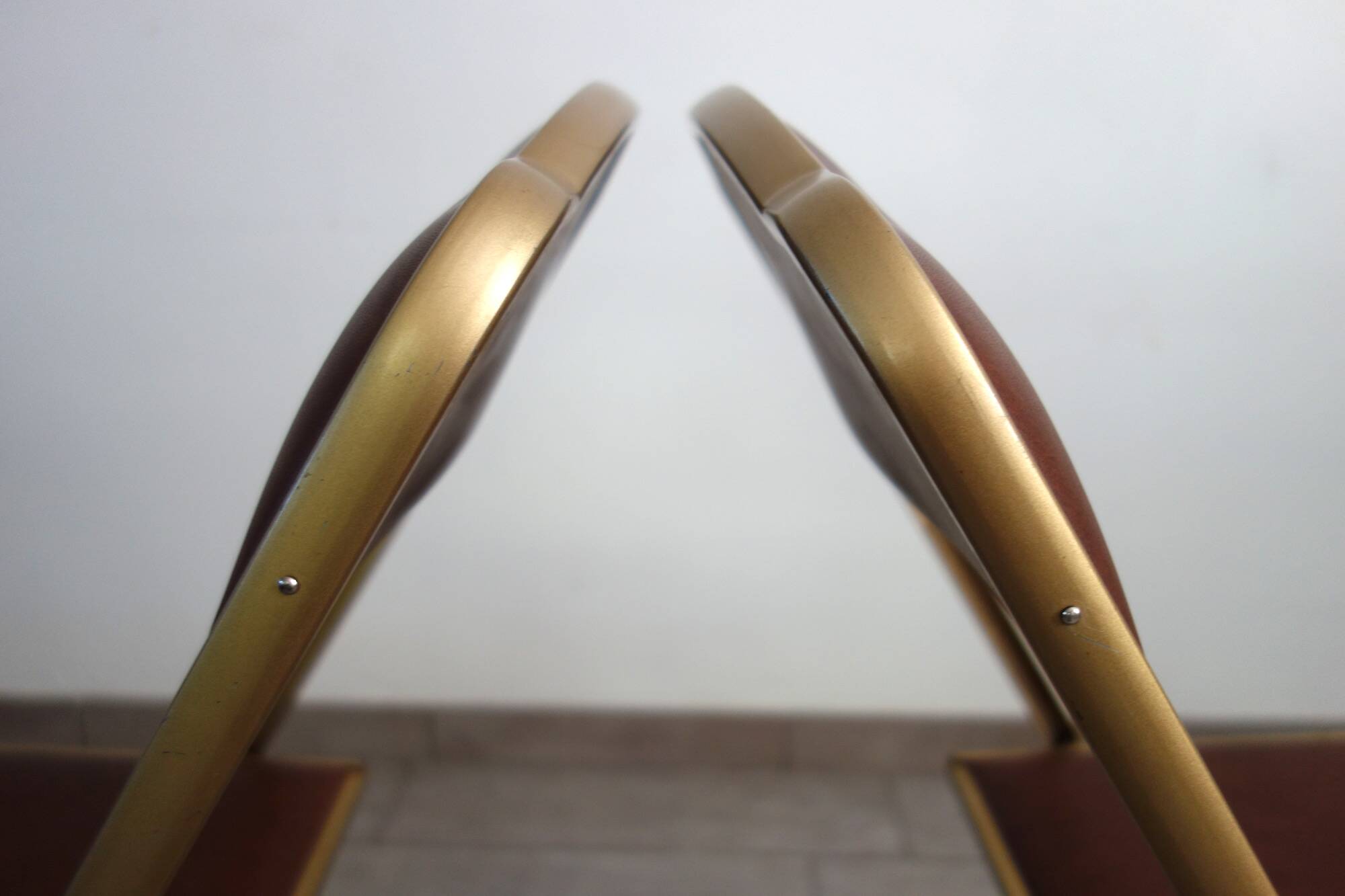2 golden metal chairs with faux leather in the 60s/70s Opera style.