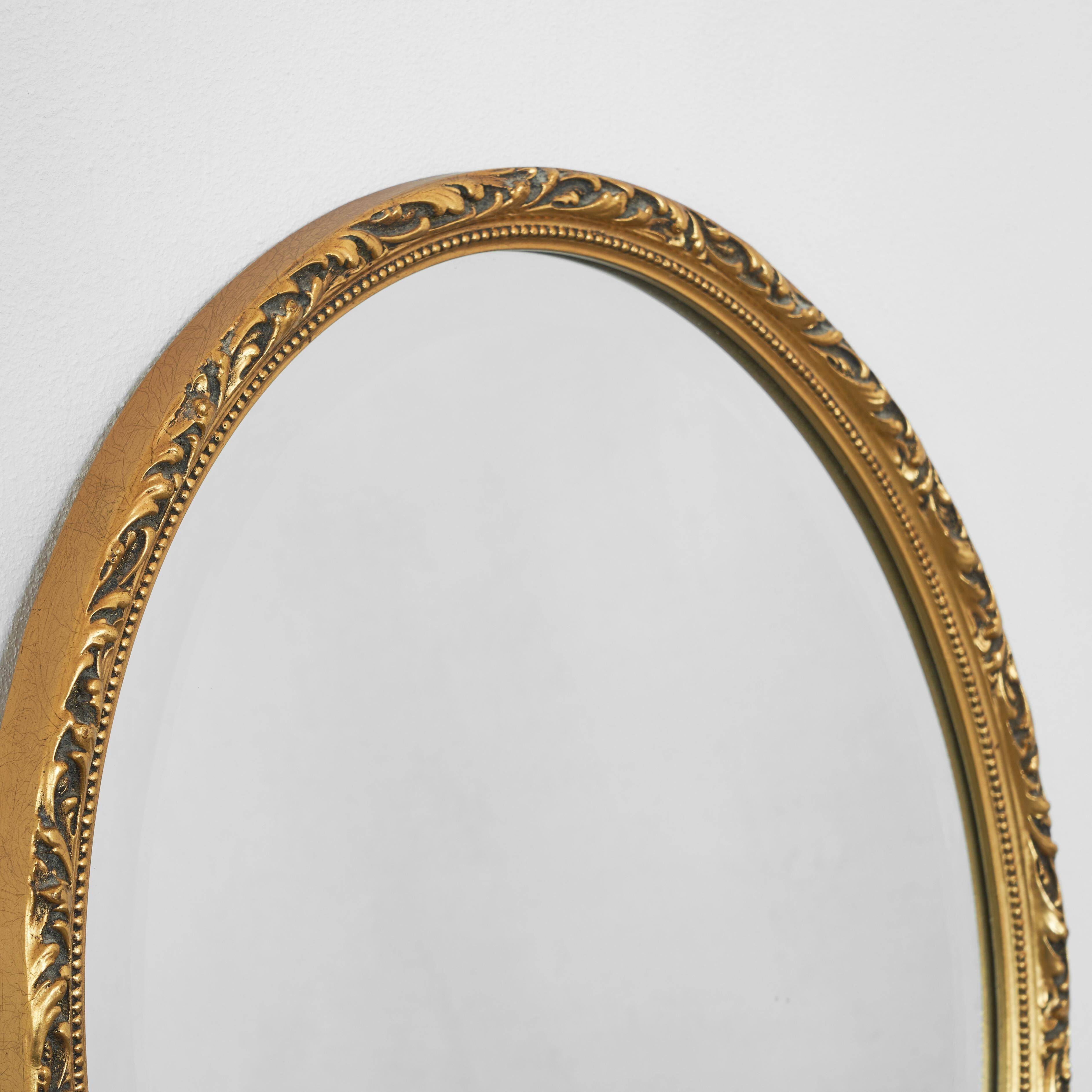 Oval mirror with gilded wood from the 1960s.