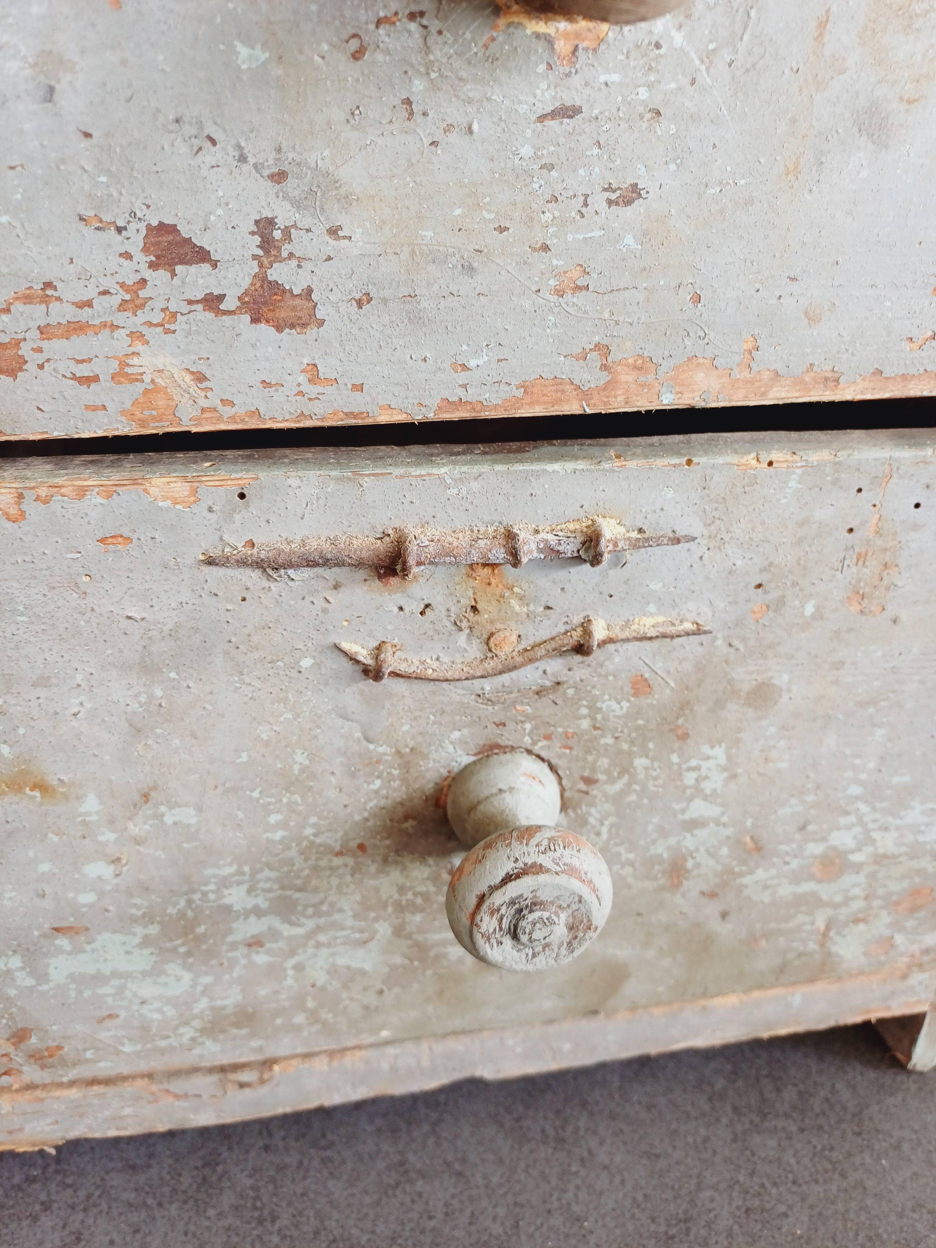 Craft cabinet with drawers with a very old tobacco advertisement in the background