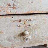 Craft cabinet with drawers with a very old tobacco advertisement in the background