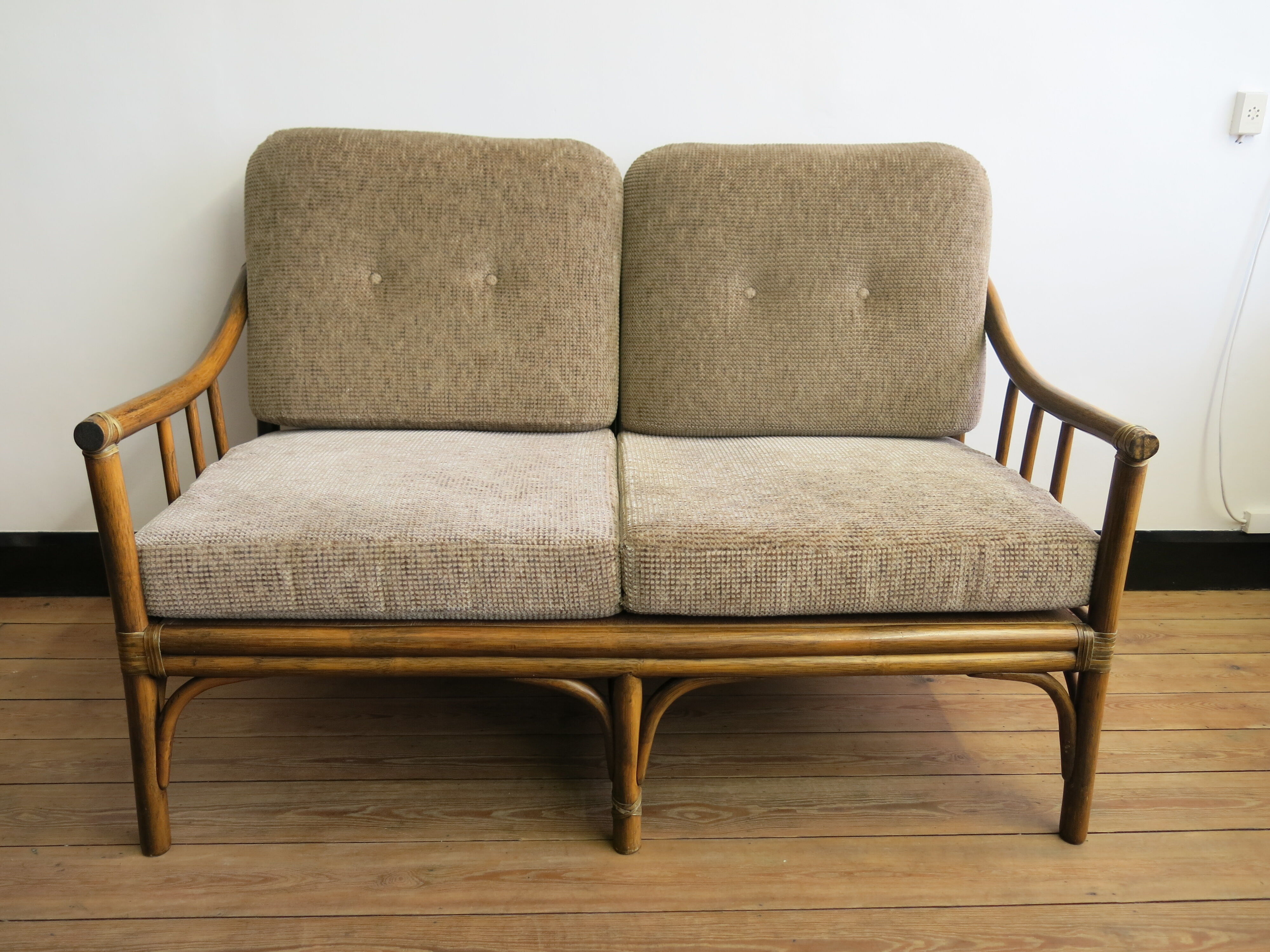 Two-seater rattan sofa with natural tones