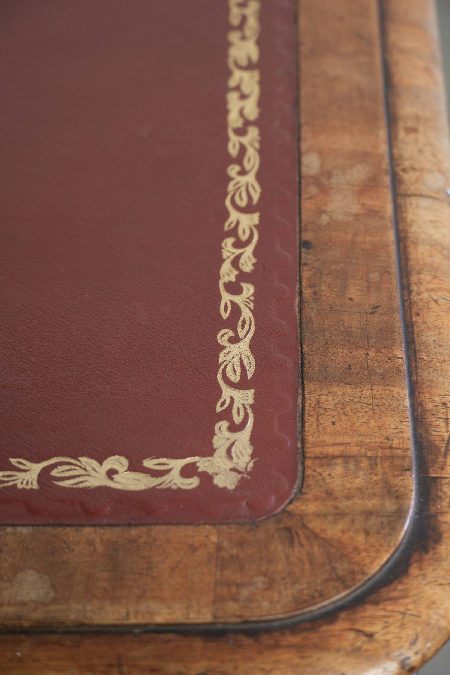 Antique English writing desk from the 19th century with a red leather top