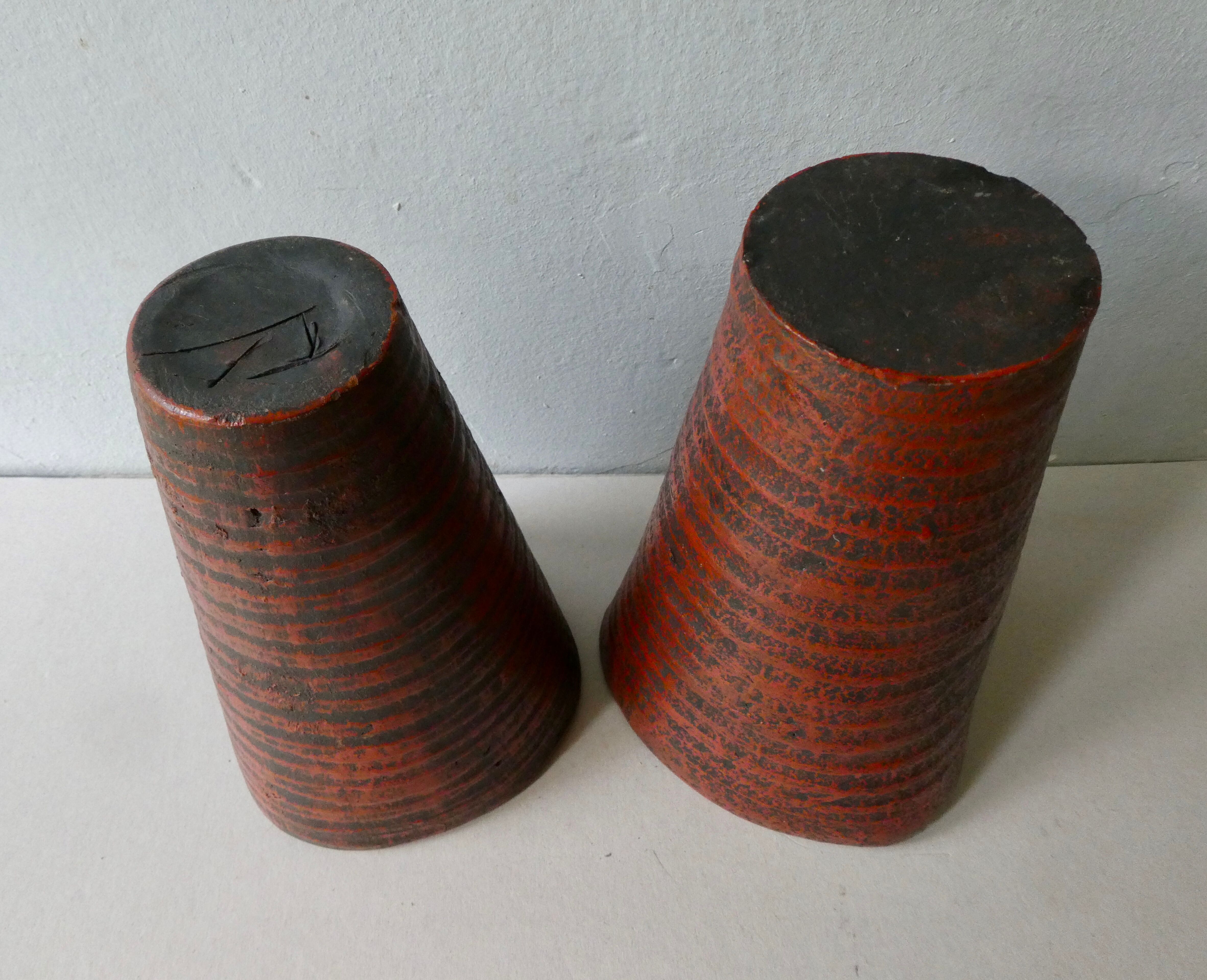 Pair of red enamelled terracotta vases, signed