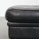 Set of a black cowhide leather Chesterfield armchair and matching ottoman