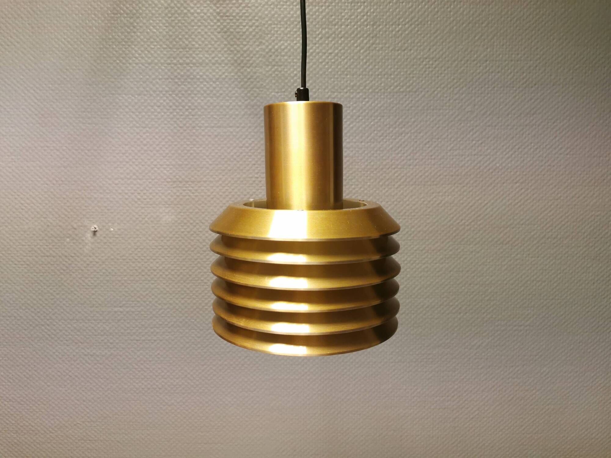 Hanging lamp in gold-colored aluminum with many layers of shades.